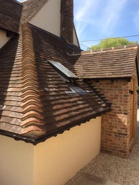 a house with a tiled roof and a brick chimney