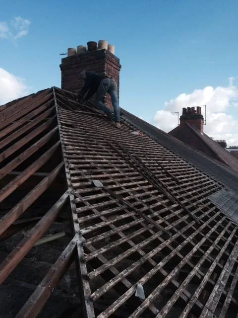 a man on a roof with a roofing tool