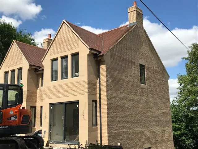 a large house with a digger in front
