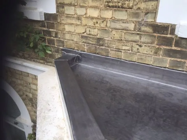 a black slate roof with a brick wall